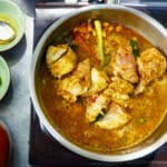 Preparation of traditional Sri Lankan curry dish with tender chicken breast at cooking class