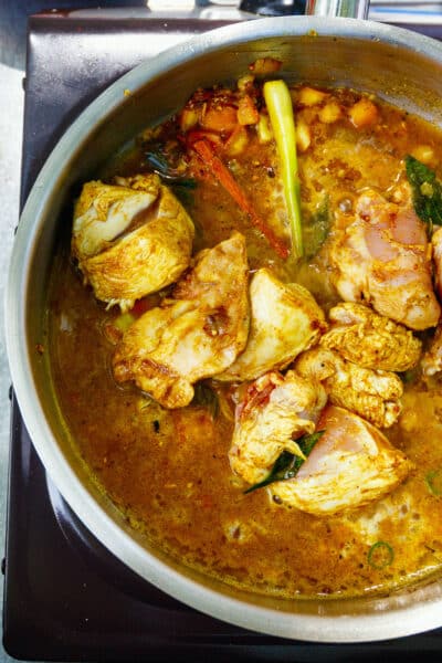Preparation of traditional Sri Lankan curry dish with tender chicken breast at cooking class