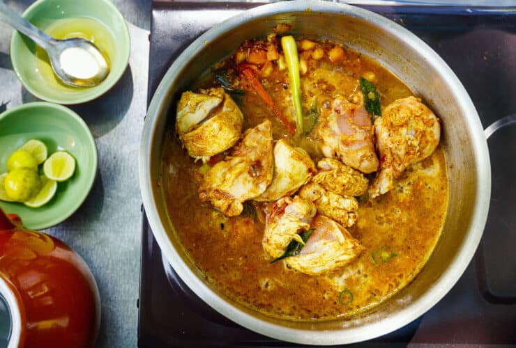 Preparation of traditional Sri Lankan curry dish with tender chicken breast at cooking class