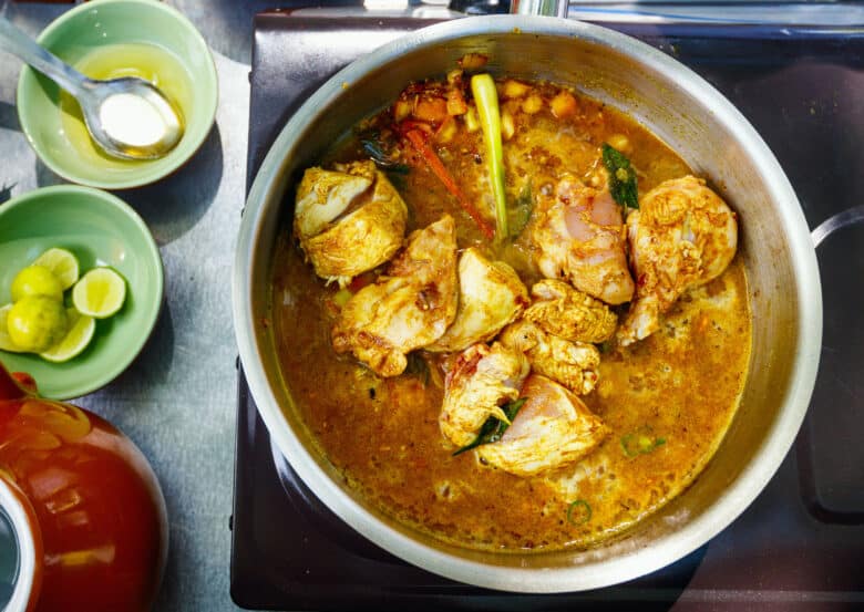 Preparation of traditional Sri Lankan curry dish with tender chicken breast at cooking class
