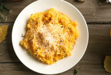 Pumpkin Risotto with herbs and parmesan cheese on wooden