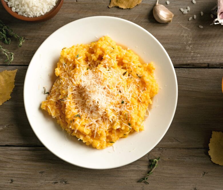 Pumpkin Risotto with herbs and parmesan cheese on wooden