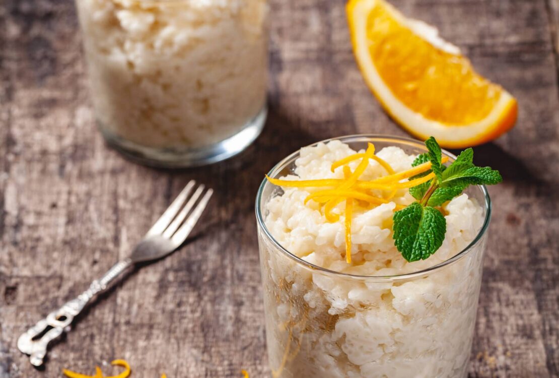 Two glasses of rice pudding on wooden rustic table. Close up. Two glasses of rice pudding on wooden rustic table. Close up