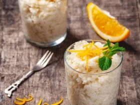 Two glasses of rice pudding on wooden rustic table. Close up. Two glasses of rice pudding on wooden rustic table. Close up