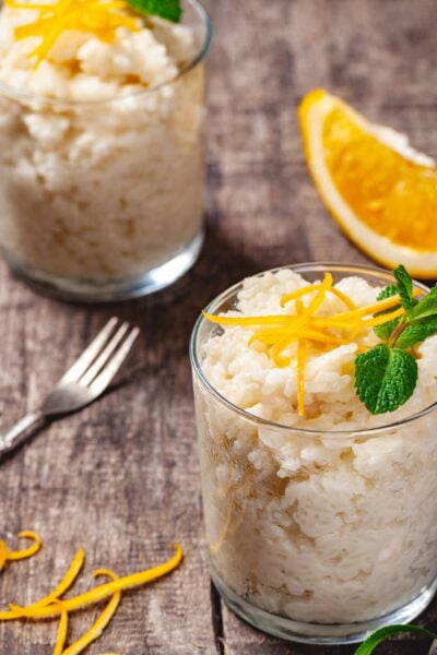 Two glasses of rice pudding on wooden rustic table. Close up. Two glasses of rice pudding on wooden rustic table. Close up