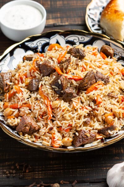 Uzbek plov a rice dish prepared with beef, stewed with fried onions, garlic and carrots rice, dried fruits, garlic and cumin.