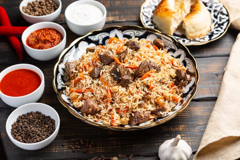Uzbek plov a rice dish prepared with beef, stewed with fried onions, garlic and carrots rice, dried fruits, garlic and cumin.