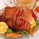 Brown sugar and honey glazed ham with carrots, herbs, fruit and bread