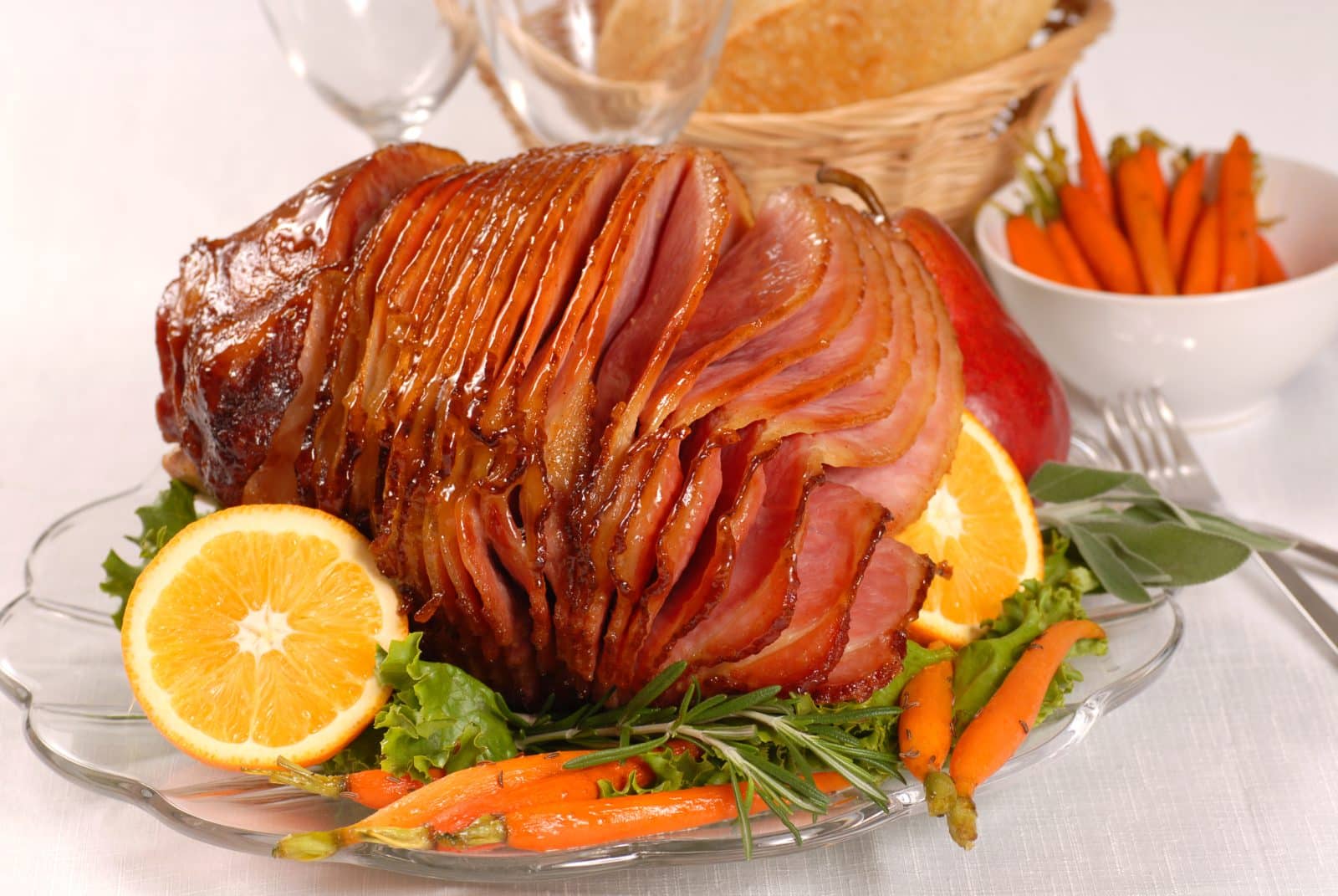 Brown sugar and honey glazed ham with carrots, herbs, fruit and bread