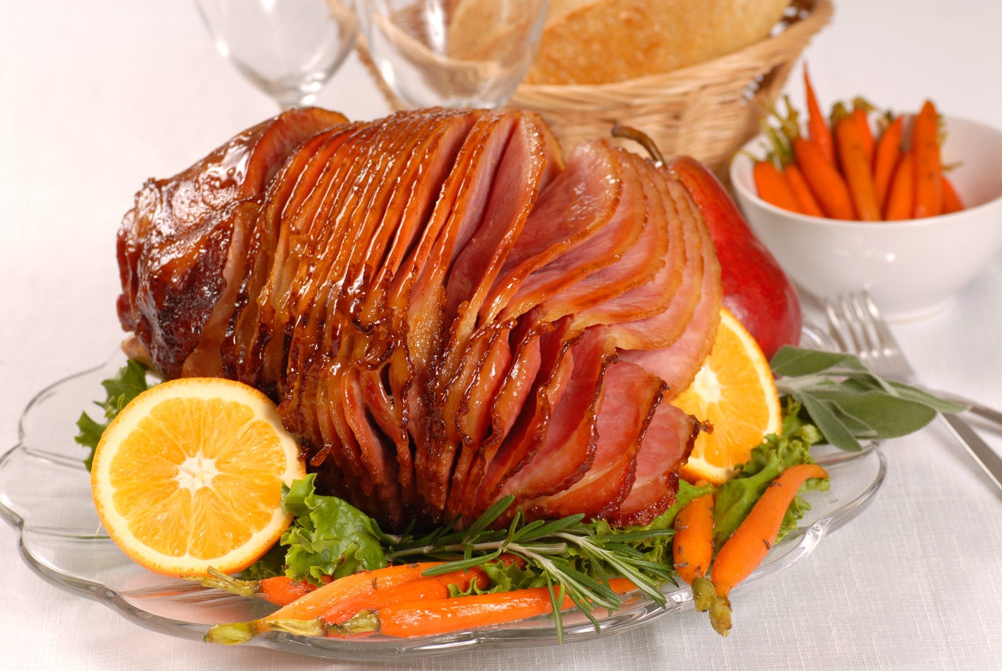 Brown sugar and honey glazed ham with carrots, herbs, fruit and bread