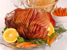 Brown sugar and honey glazed ham with carrots, herbs, fruit and bread