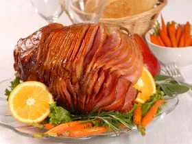 Brown sugar and honey glazed ham with carrots, herbs, fruit and bread