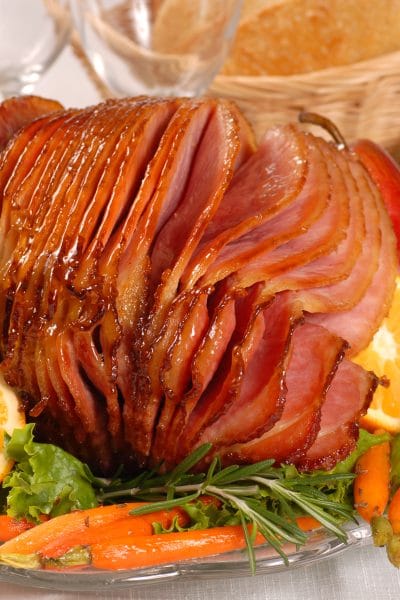 Brown sugar and honey glazed ham with carrots, herbs, fruit and bread